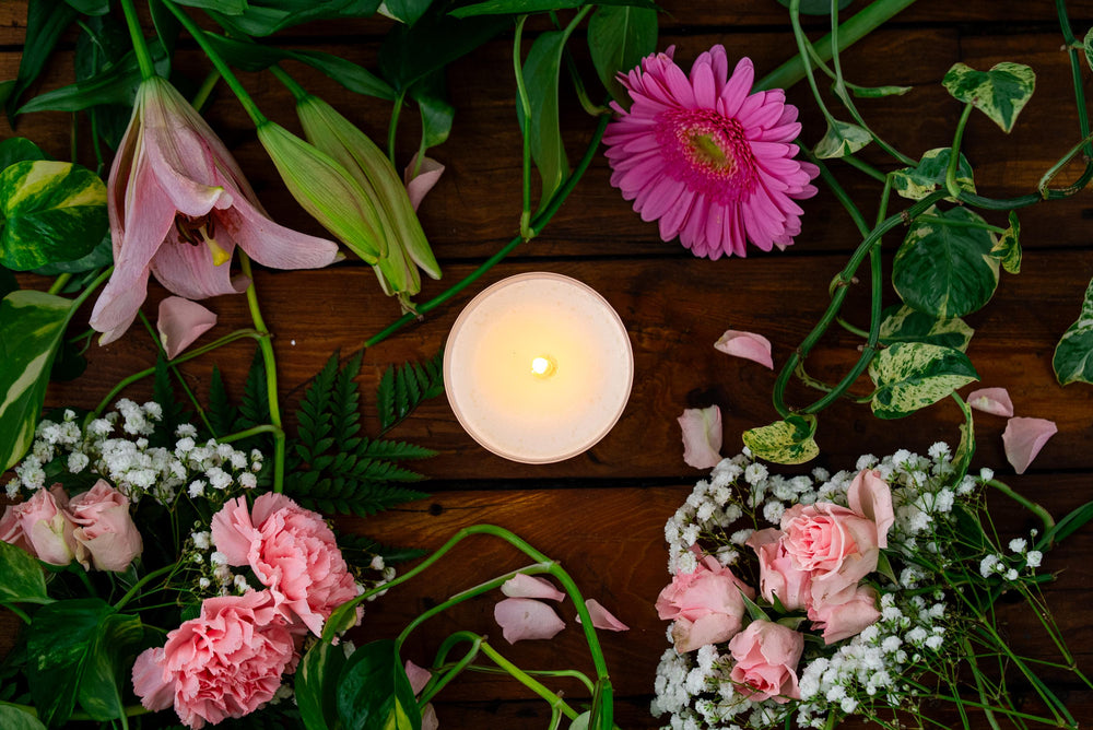 Minerva Unconditional rose and peony candle among pink lilies, gerberas and carnations