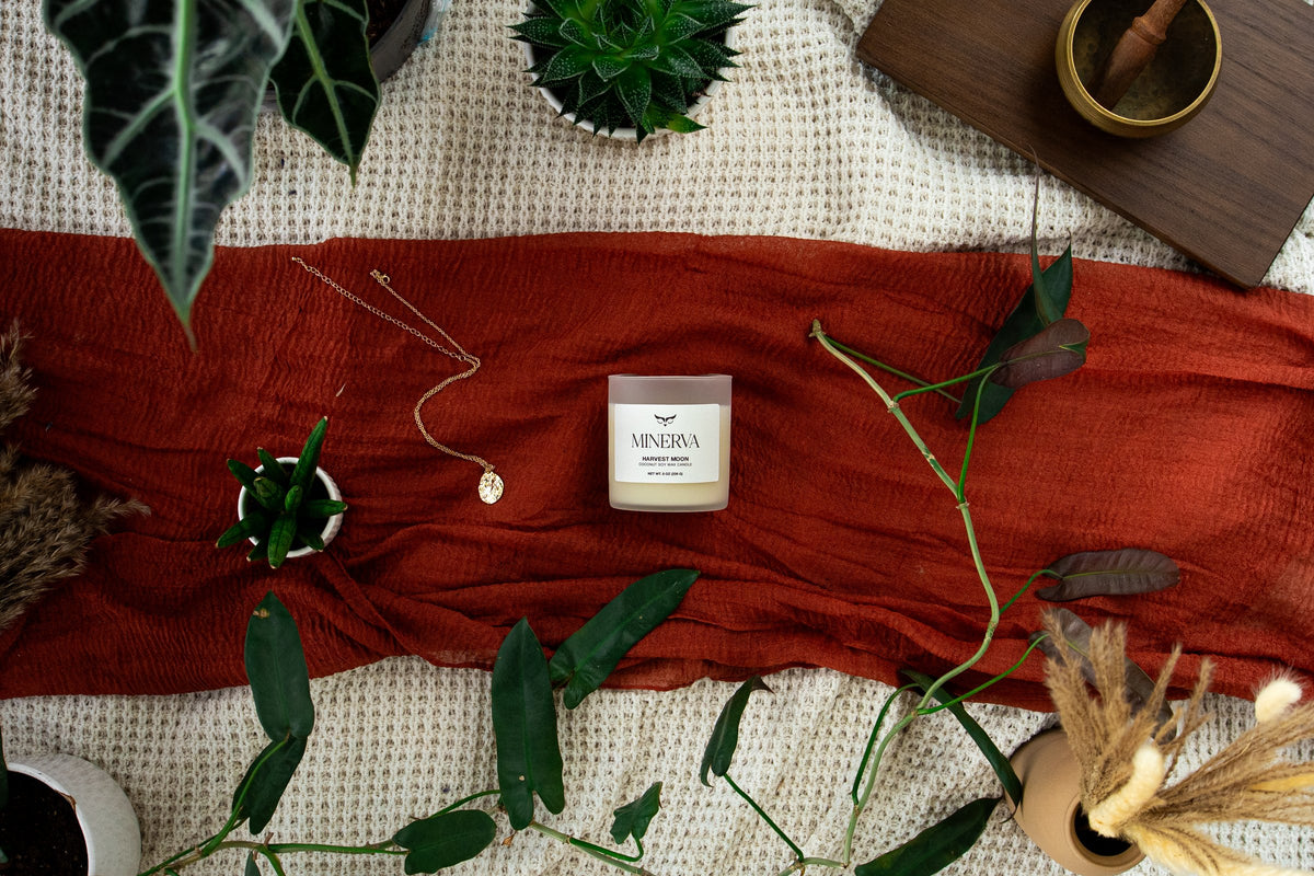 Minerva Palo Santo candle resting on a deep green linen cloth